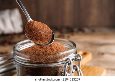 Instant Coffee And Spoon Above Glass Jar On Table, Closeup