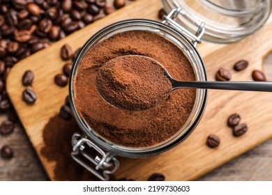 Instant Coffee And Spoon Above Glass Jar On Wooden Table, Flat Lay