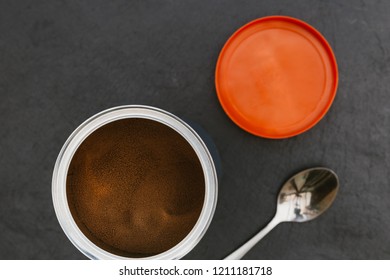 Instant Coffee In Tin Jar With Spoon On Dark Background