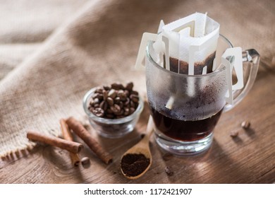 Instant Drip Coffee Using Paper Type Filter With Beans And Cinnamon On Wooden Background