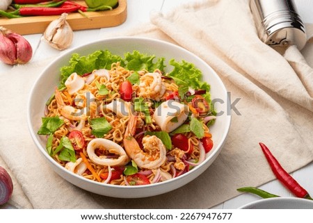instant noodle spicy salad.Thai hot and sour noodle salad with squid shrimp and minced pork that is very flavorful and addictive