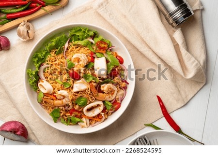 instant noodle spicy salad.Thai hot and sour noodle salad with squid shrimp and minced pork that is very flavorful and addictive.Top view