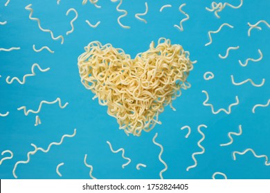 instant noodles advertisement photo. levitated noodle heart symbol over blue trendy background. outer space. for design and ornate. love fast food concept.