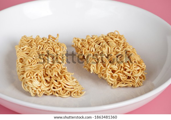 The instant noodles are divided into\
2 parts, placed on a white plate. Food sharing\
concept