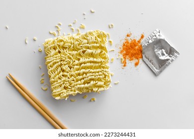 Instant noodles with seasonings on the table.  Uncooked noodles with red chilli powder.  Flat lay top view food photography.  Food from above concept.