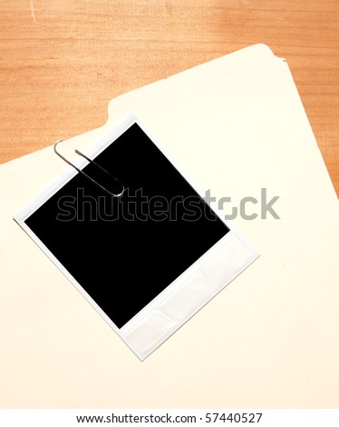 instant photograph clipped to a plain folder