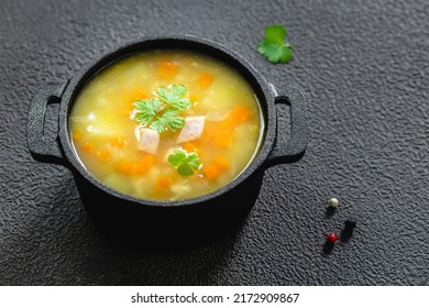 Instant pot bacon split pea soup in cast iron pot on dark background. Top view, copy space, flat lay.