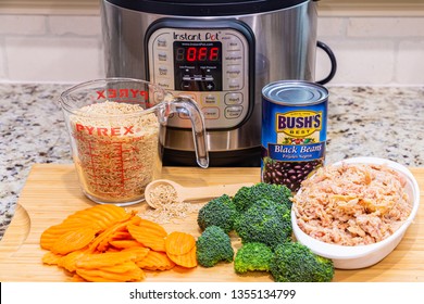 Instant Pot dinner preparation with brown rice, carrots, broccoli, chicken and black beans