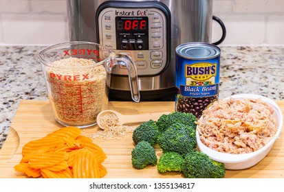 Instant Pot Dinner Preparation With Brown Rice, Carrots, Broccoli, Chicken And Black Beans