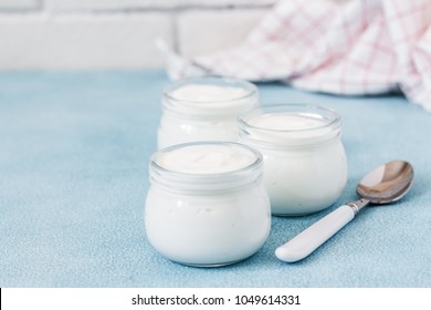 Instant pot homemade yogurt in glass jars on light blue background. Selective focus, copy space.