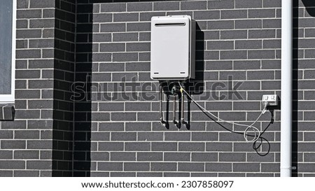 Instantaneous gas hot wate heater on the side of a building