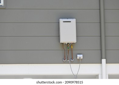 Instantaneous gas hot water heater on the side of a house  - Shutterstock ID 2090978515