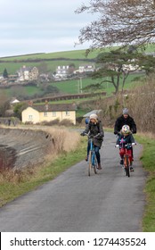 Instow, North Devon, England, UK. January 2019. Family Cycling Along The South West Coastal Path In Winter.