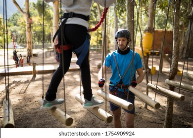 Instructor assisting kid in zip line on a sunny day - Powered by Shutterstock