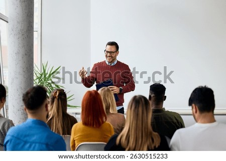 Instructor delivering a workshop to a group of attendees in a bright modern space.