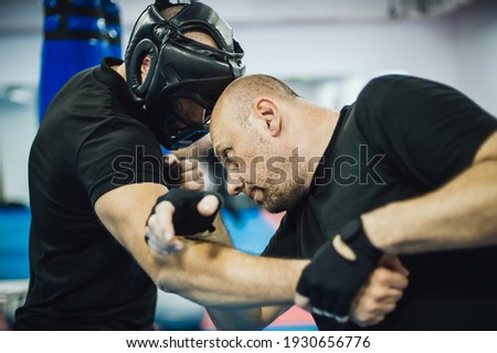 Instructor demonstrate headbutt street fight technique against attacker. Head kick. Martial arts practice