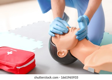 Instructor Demonstrating CPR On Mannequin At First Aid Training Course