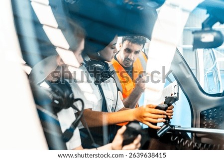 Instructor explaining aircraft controls to two pilot students during flight training inside cockpit simulator