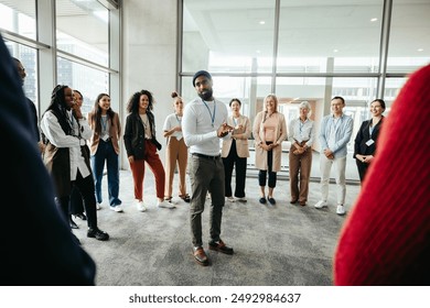 Instructor guides team building exercise at conference with a diverse group of people. Concept of teamwork, communication, and learning in a professional setting.