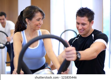 Instructor In A Gym Explains A Vibration Plate To A Woman