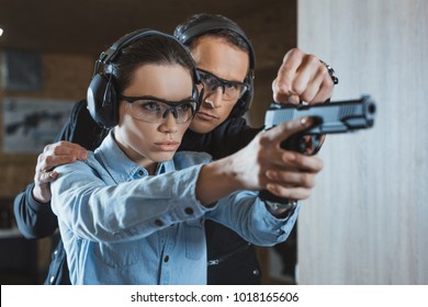instructor helping customer in shooting gallery
