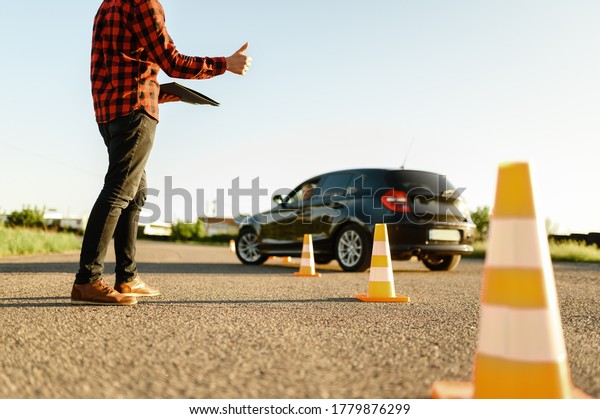 Instructor helps\
student to drives between\
cones