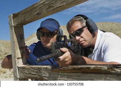 Instructor With Man Aiming Machine Gun At Firing Range