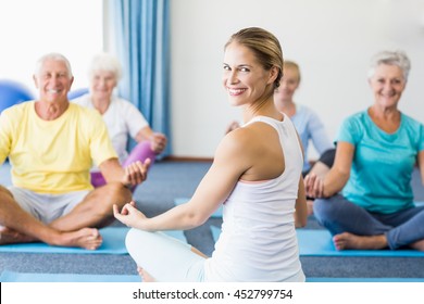 Instructor Performing Yoga With Seniors During Sports Class