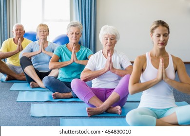 Instructor Performing Yoga With Seniors During Sports Class