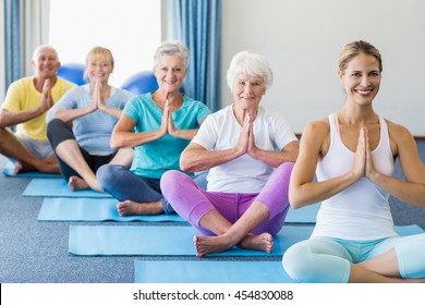 Instructor Performing Yoga With Seniors During Sports Class