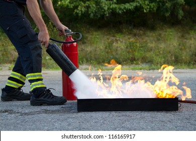 Instructor Showing How To Use A Fire Extinguisher On A Training Fire