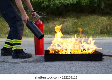 Instructor Showing How To Use A Fire Extinguisher On A Training Fire