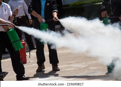 Instructor Showing How To Use A Fire Extinguisher On A Training Fire