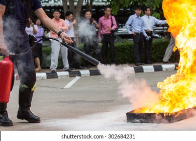 Instructor Showing How To Use A Fire Extinguisher On A Training Fire