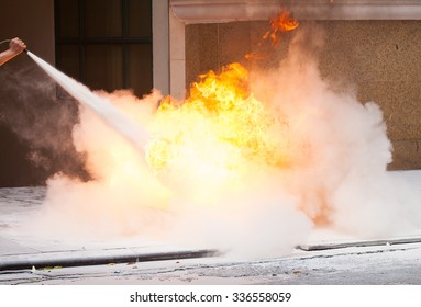 Instructor Showing How To Use A Fire Extinguisher On A Training Fire