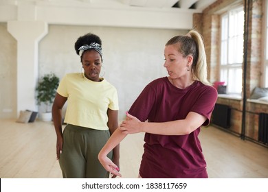 Instructor showing the movement to dancer during sports training in dance studio