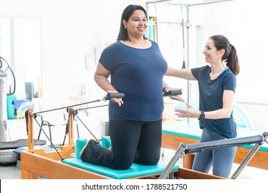 Instructor and student in pilates class. Well-being concept for older people.