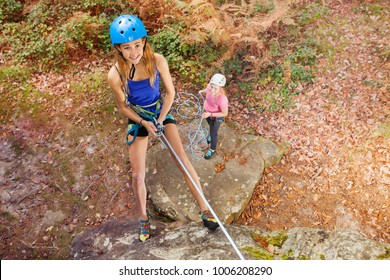 Instructor Teaching Teenager To Abseil Outdoors