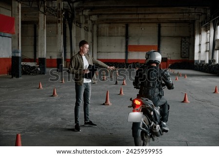 Instructor teaching young biker at personal lesson at motorcycle school