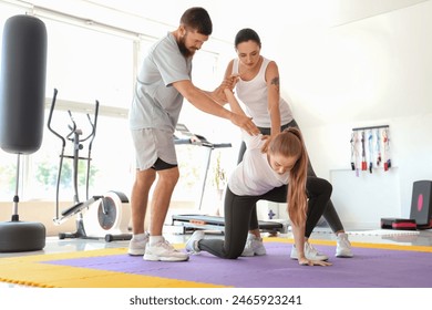 Instructor teaching young women to fight in gym. Concept of self defense - Powered by Shutterstock