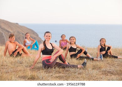 Instructor Trains Yoga Kids In The Mountains On The Ocean