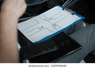 Instructor using a special scheme of road traffic rules during training at a driving school. Close up. Driving test, driver courses, exam concept - Powered by Shutterstock