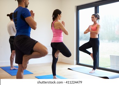 Instructor With Yoga Class At Gym