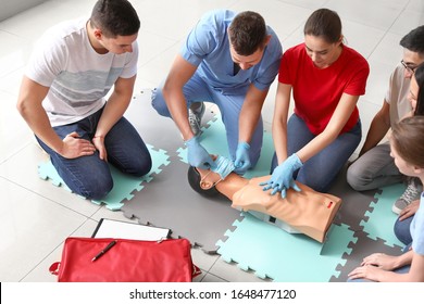 Instructors Demonstrating CPR On Mannequin At First Aid Training Course