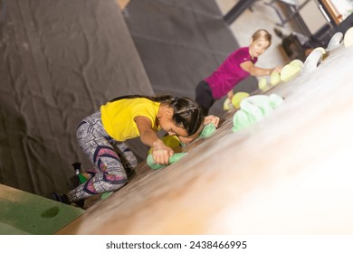 Instructors helping children climb wall in gym - Powered by Shutterstock