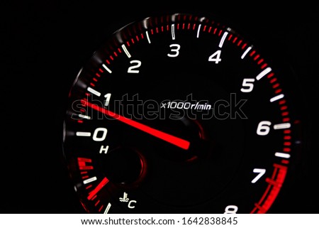 Instrument panel with tachometer and fuel level temperature engine, Close up image of illuminated car dashboard. Red arrow moving