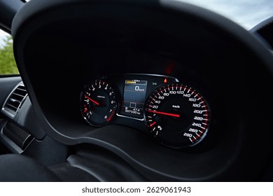 Instrument panel with tachometer and speedometer. Close up image of illuminated car dashboard.