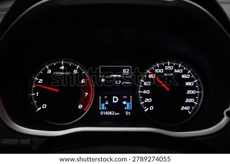 Instrument panel with tachometer and speedometer. Close up image of illuminated car dashboard.