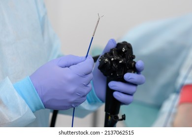 Instruments for gastroscopy close-up. The doctor holds in his hands a flexible endoscope and forceps to remove foreign bodies from the esophageal cavity. Endoscopy and minimally invasive surgery.