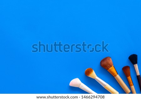 Instruments for make up with brushes on blue background top view mock up